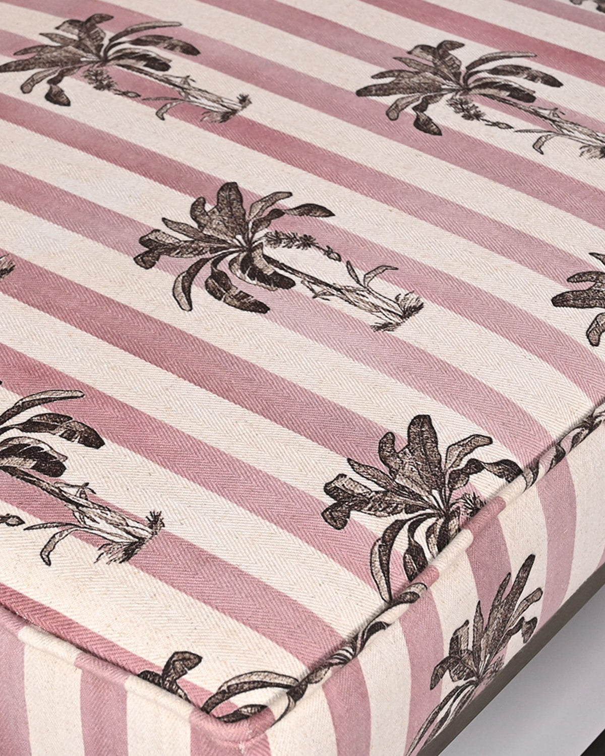 Close-up of the Bay Chair’s pink striped fabric with black palm tree motifs.