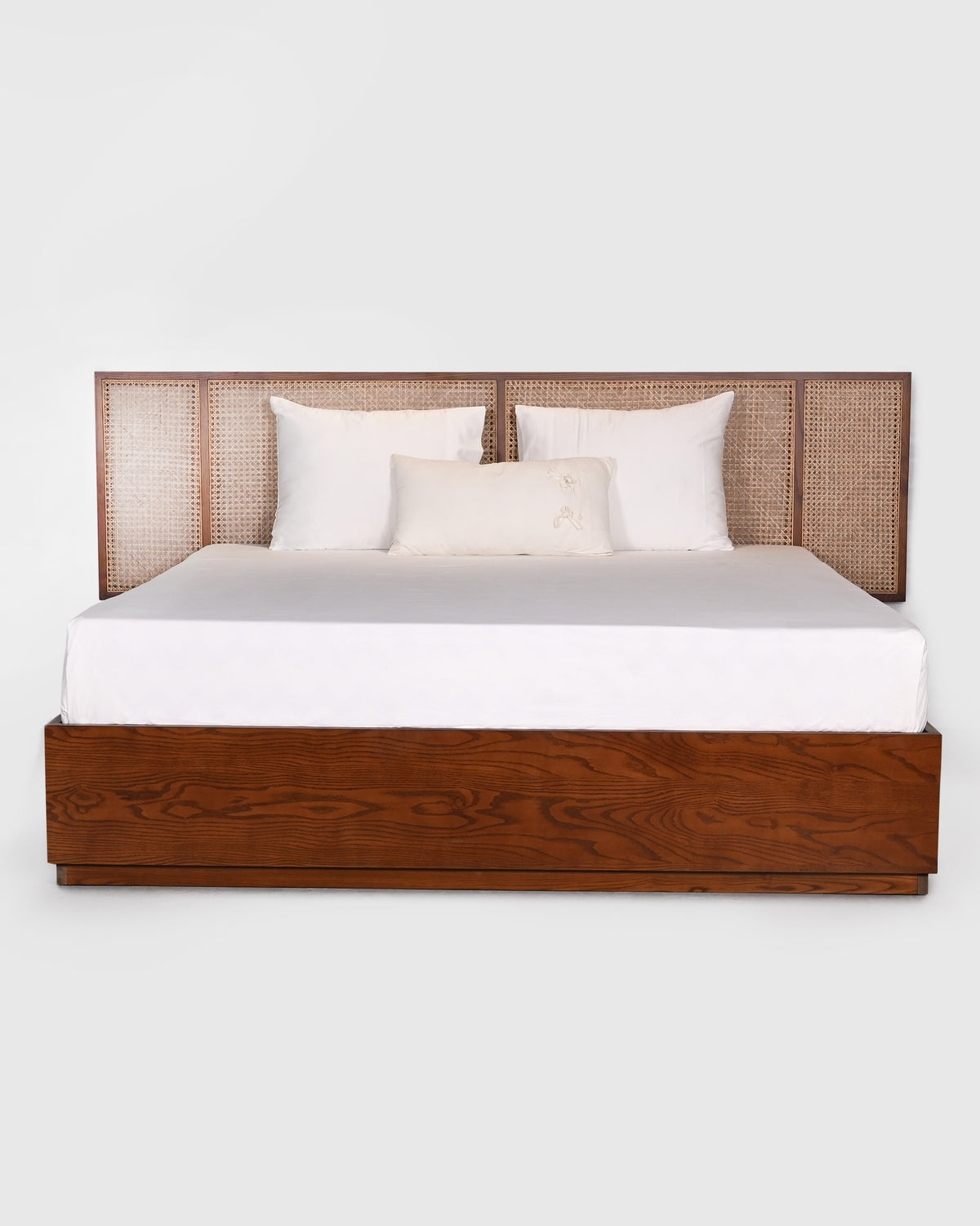 Solstice bed with a dark wood frame and woven cane headboard panels.