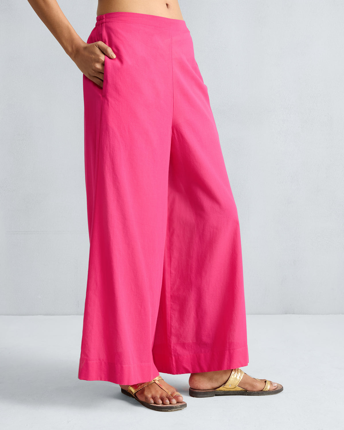 Side view of fuchsia Basic Pyjamas with a hand in the side pocket.