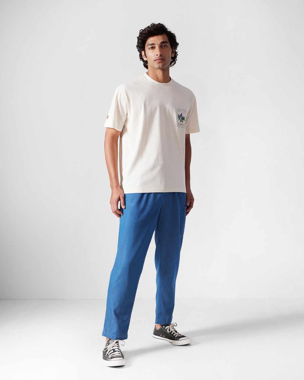 Person wearing an ivory Bulbul t-shirt with a chest stamp graphic.