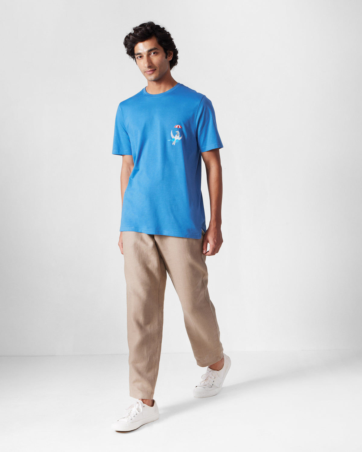 Person wearing a riverside blue Everyday t-shirt with a bird chest motif.