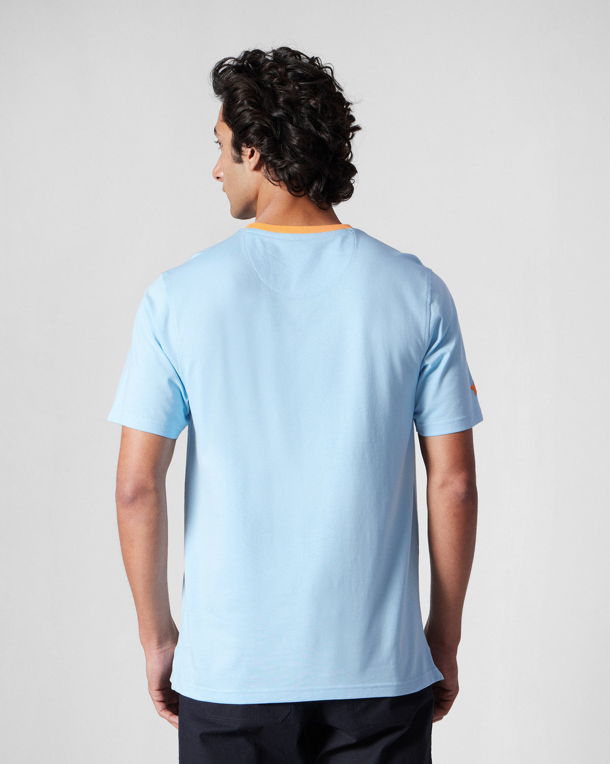 Back of an ice blue Everyday T-Shirt with an orange collar.
