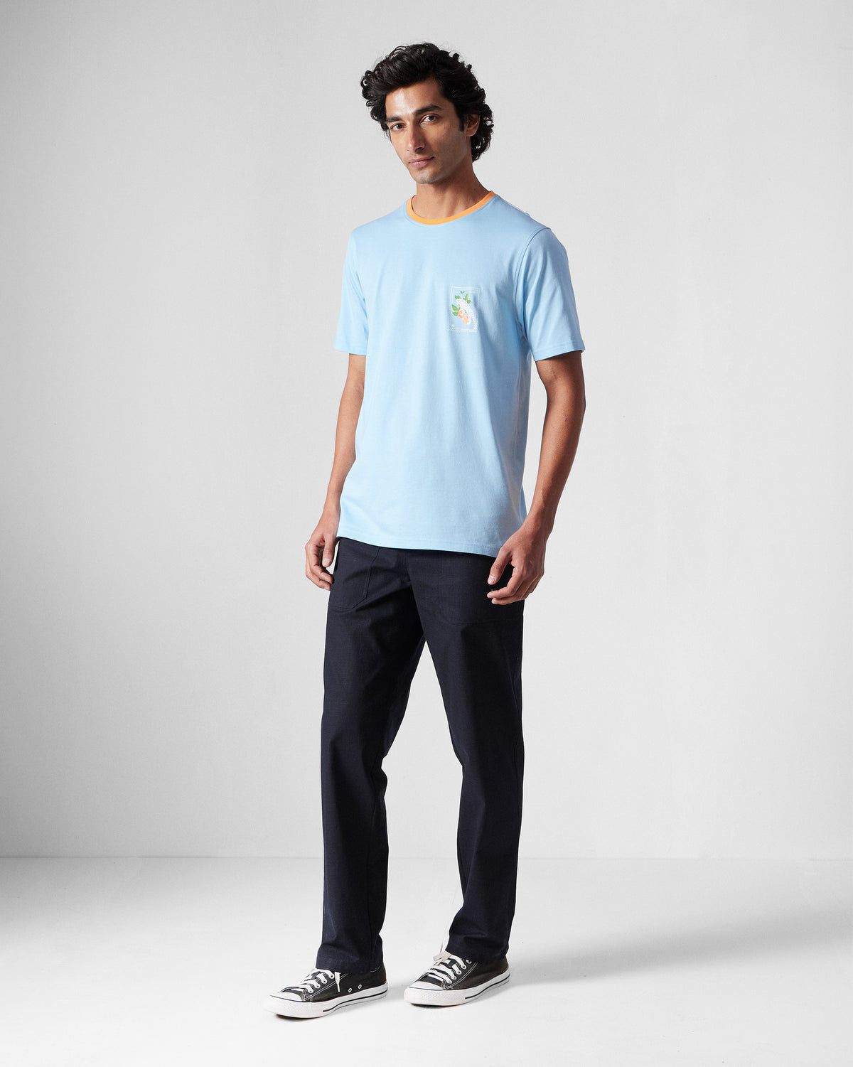 Person wearing an ice blue Everyday T-Shirt with an orange collar.