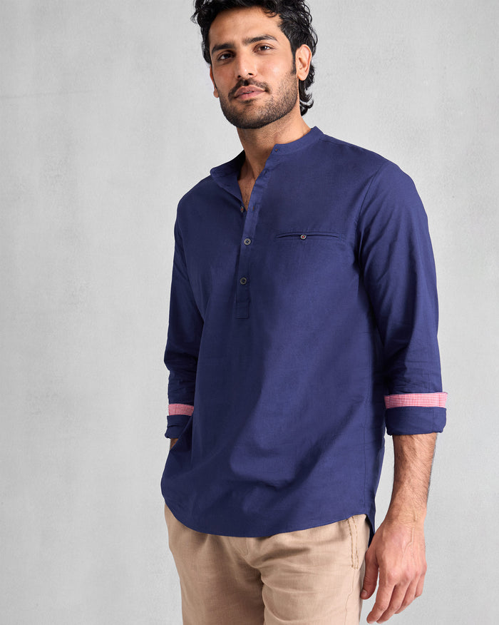 Person wearing an ink blue Pondicherry Shirt with rolled sleeves and pink cuff lining.