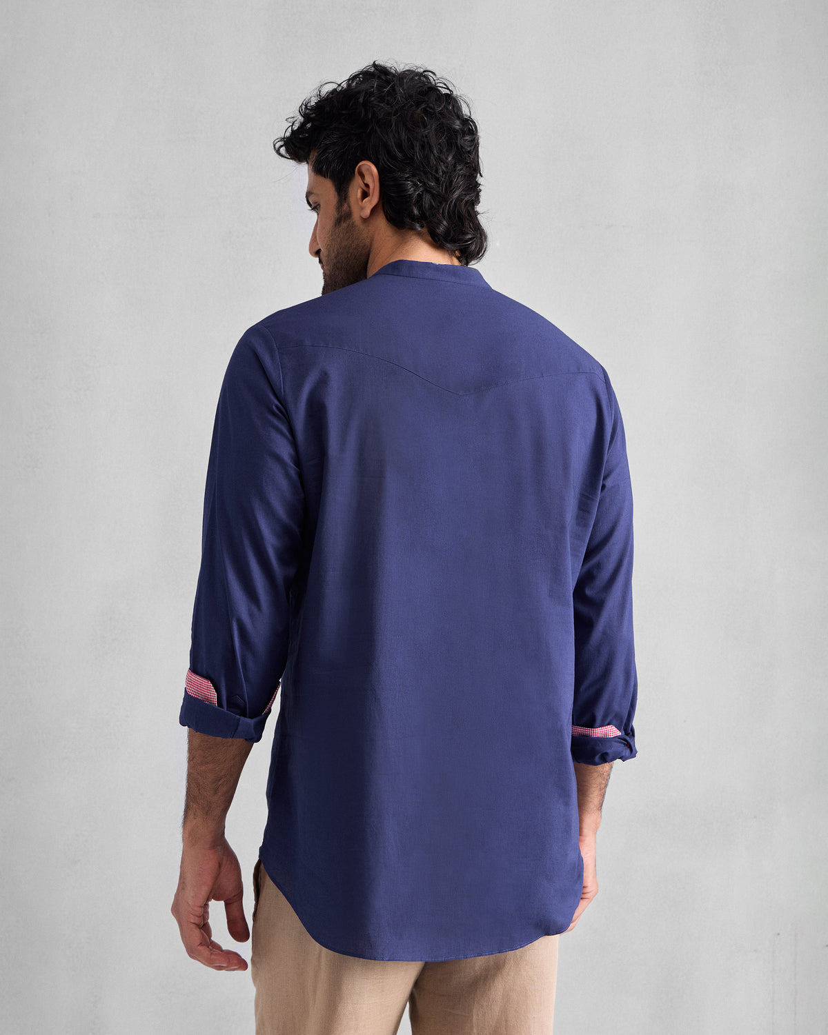 Back of an ink blue Pondicherry Shirt with a curved yoke and pink cuff lining.