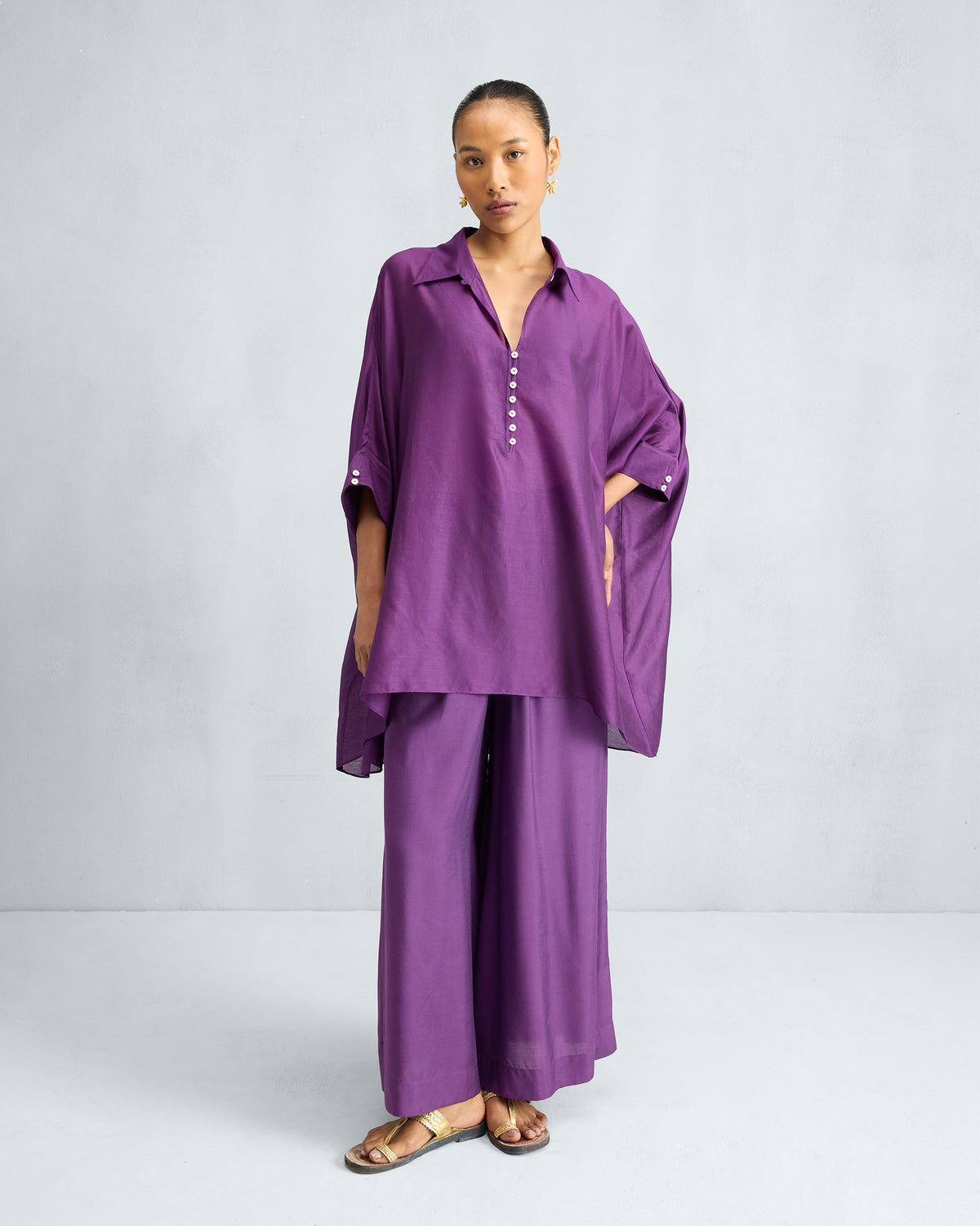 Person wearing purple Basic Pyjamas tunic and matching wide-leg trousers.