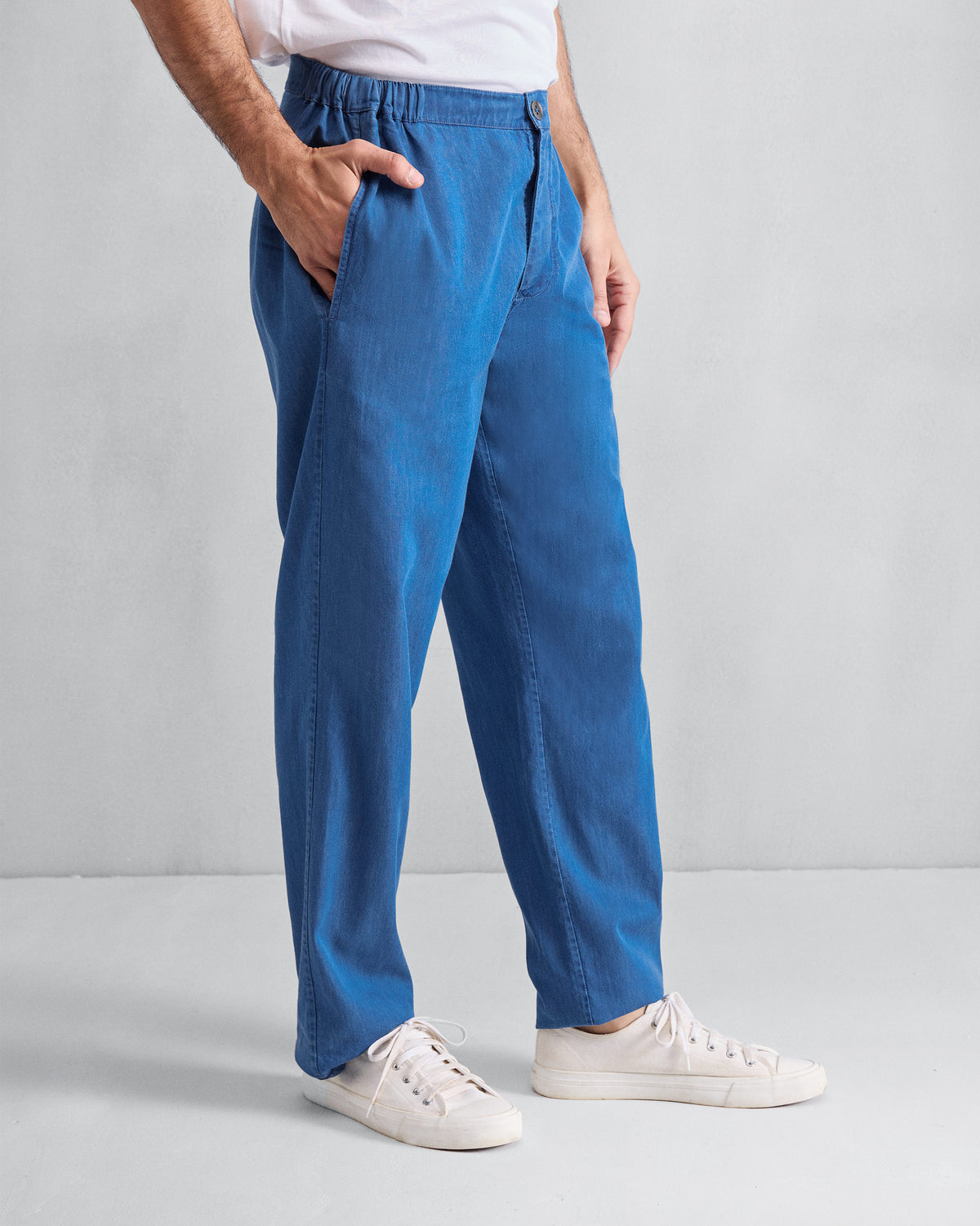 Side view of denim blue Meadow Pants with a relaxed straight leg.