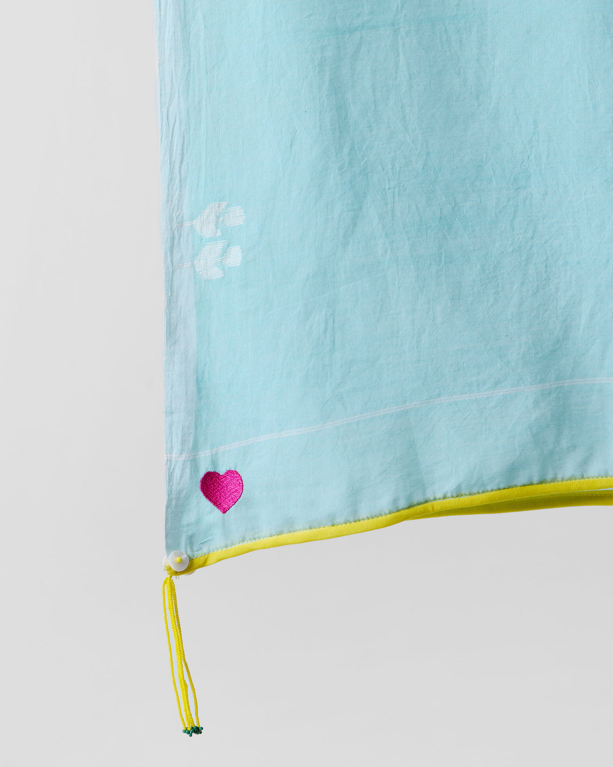 Close-up of Sky Jamdani scarf corner showing a pink heart and yellow edge.