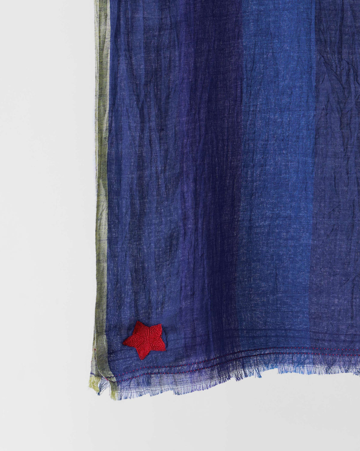 Close-up of a dark blue Everyday Stripes scarf showing a small red star.