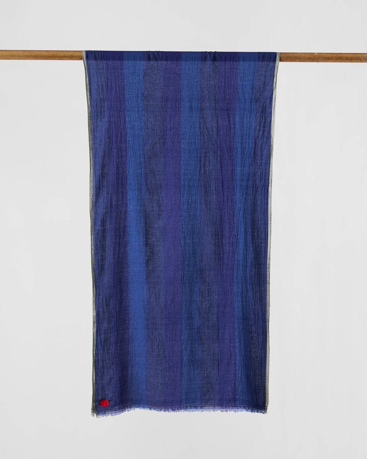 Everyday Stripes scarf hung flat in dark blue with a small red star at one corner.