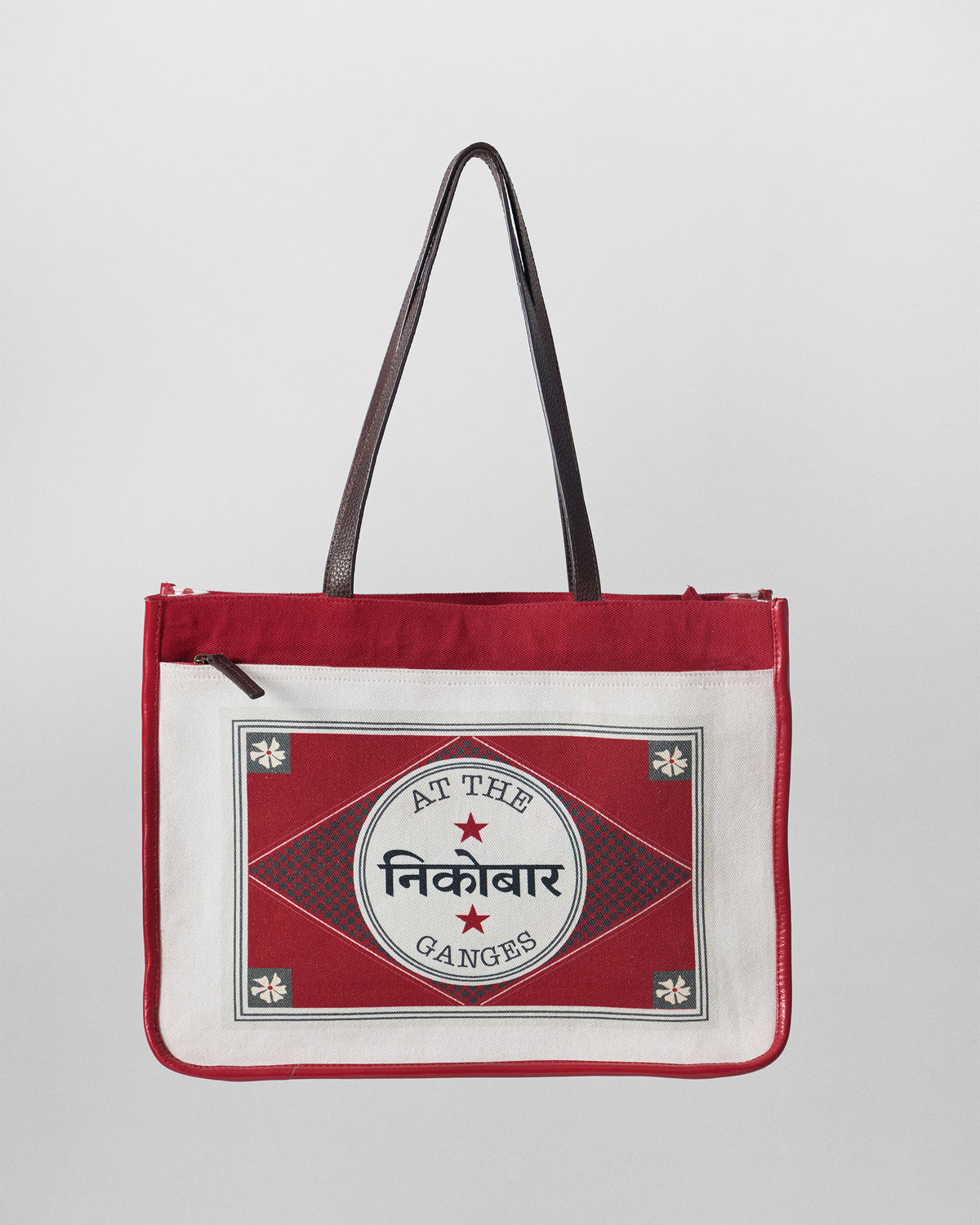 Ivory and red Ganges tote with a matchbox stamp and front zip pocket.