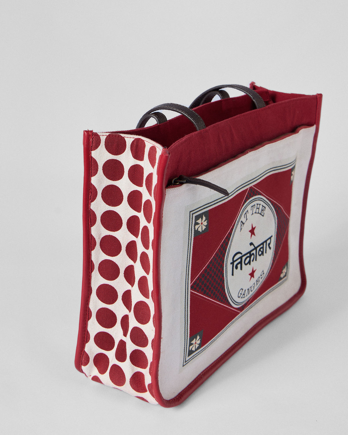 Three-quarter view of a Ganges tote with a red polka-dot side.