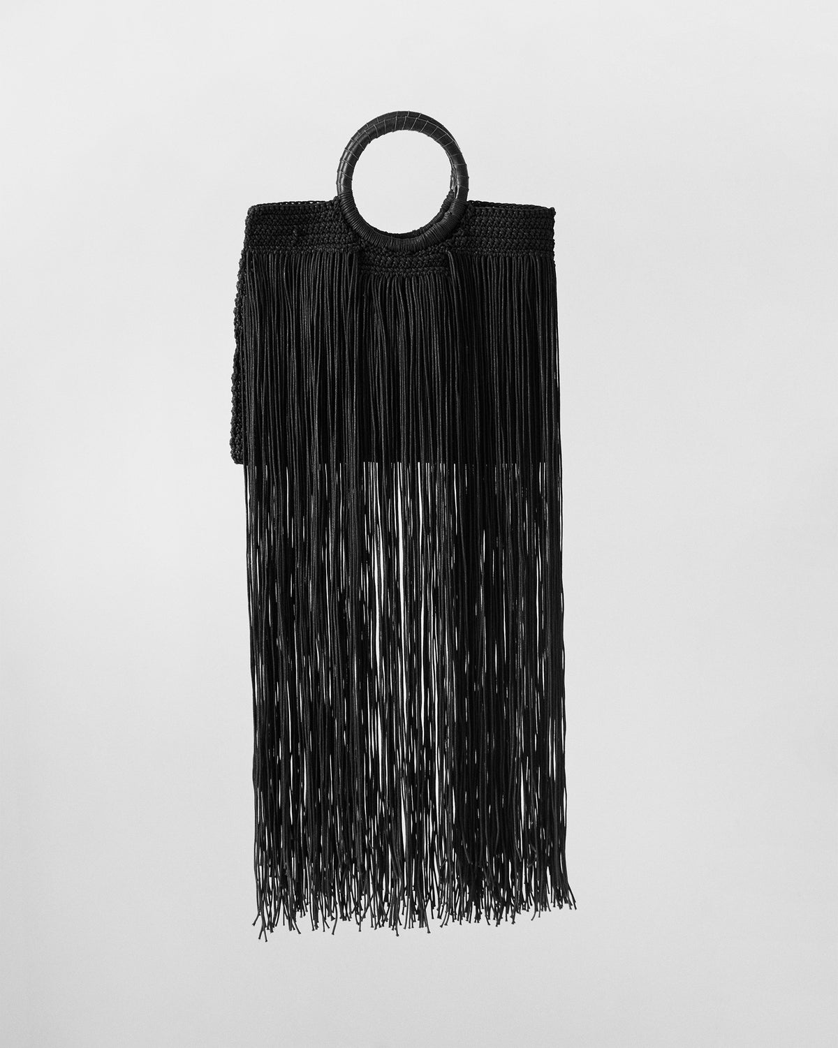 Black braided fringe bag showing dense long fringe from the body.