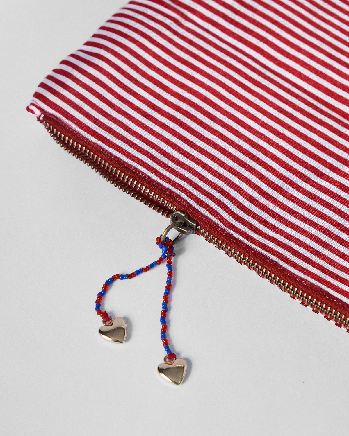 Close-up of the heart-tipped zip pulls on the Fold Over Clutch.