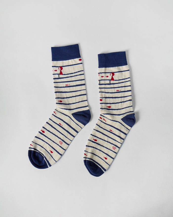 Pair of Go Fish socks laid flat, with navy stripes and red fish motifs.