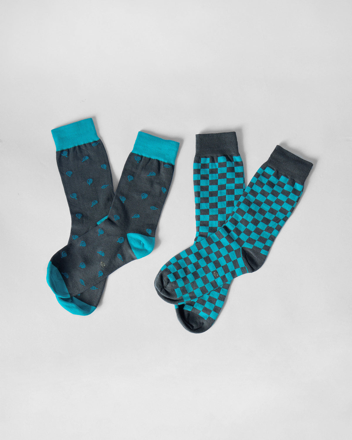 Ice blue and charcoal Tile Pop Socks laid flat in motif and checkerboard pairs.