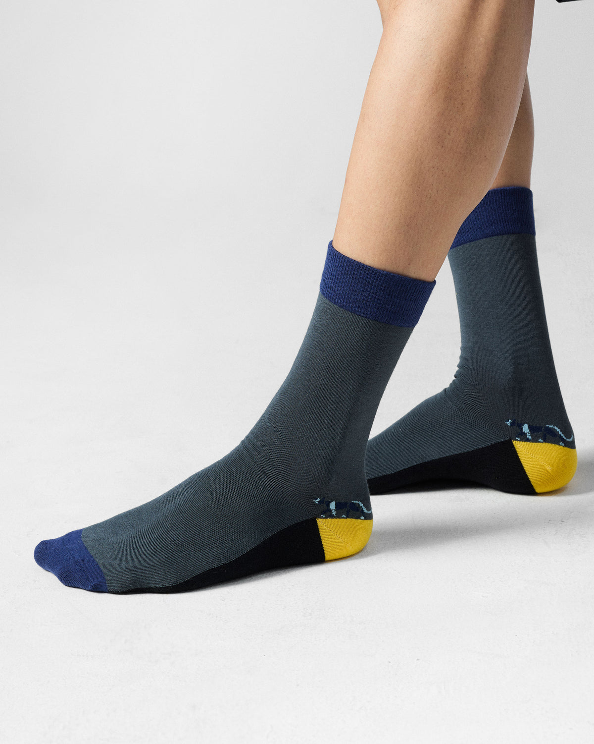 Charcoal Men's Stride Socks with a yellow heel and navy accents.