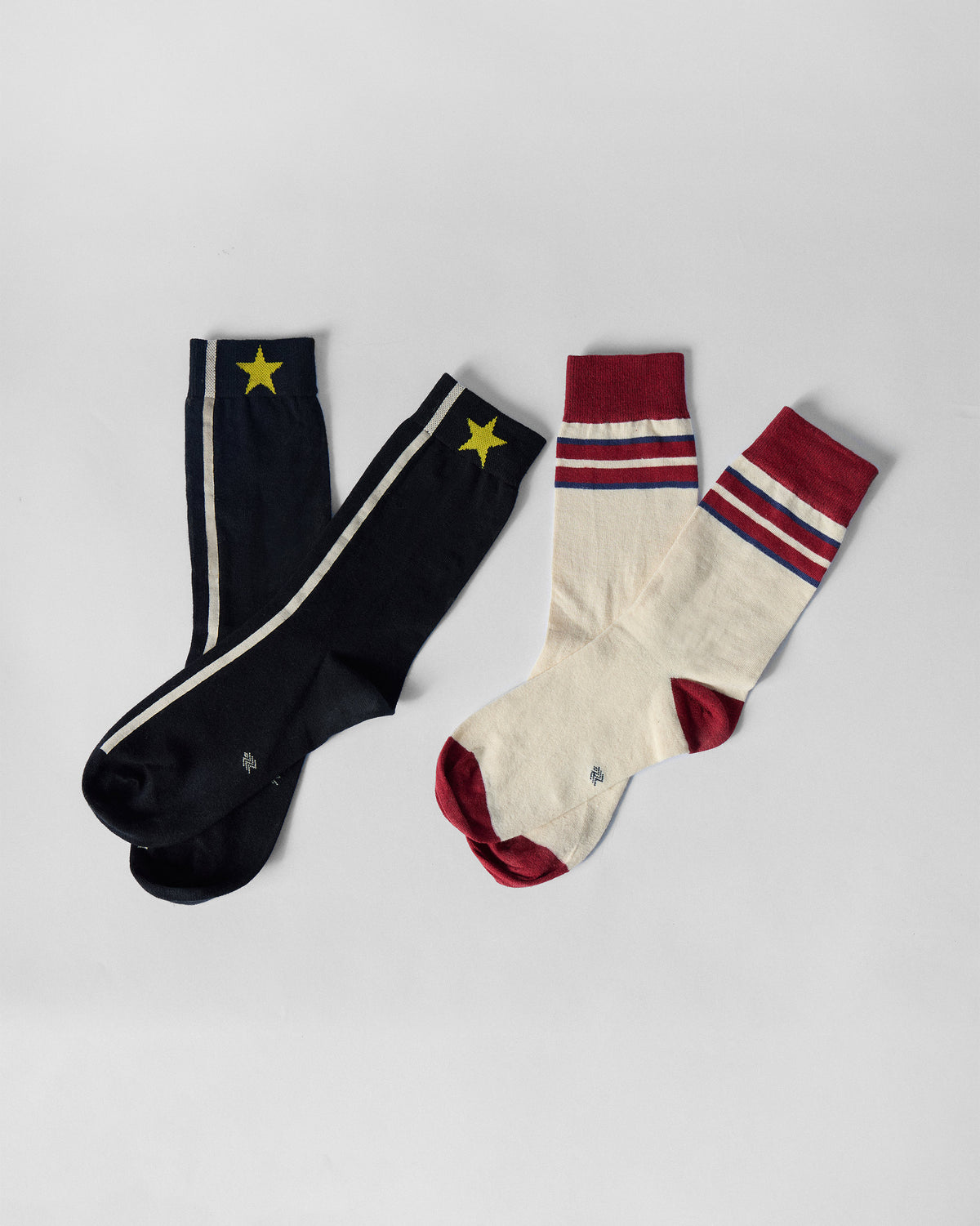 Men's Orbit Socks in black with a yellow star and cream with maroon.