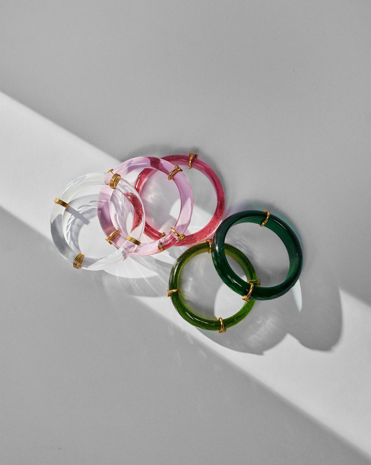 Set of five translucent Baraat bangles in pink and green with gold accents.