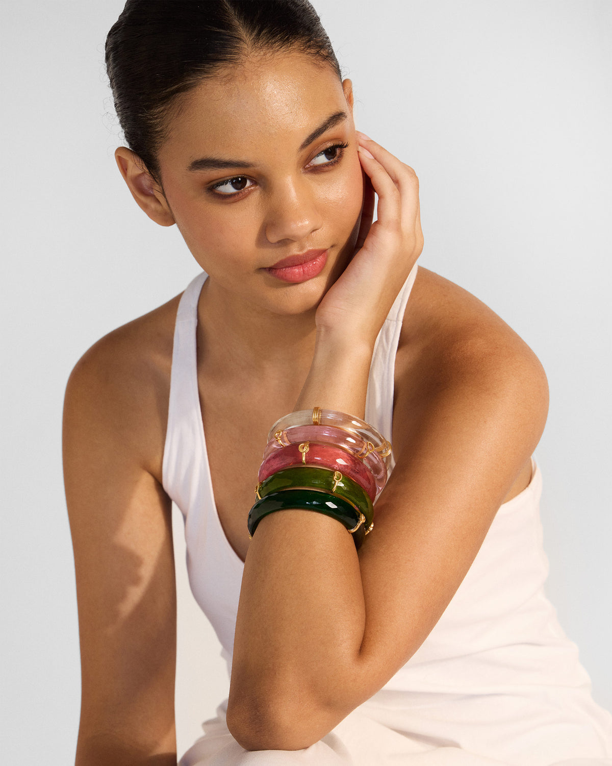 Person wearing a stack of translucent pink and green Baraat bangles.
