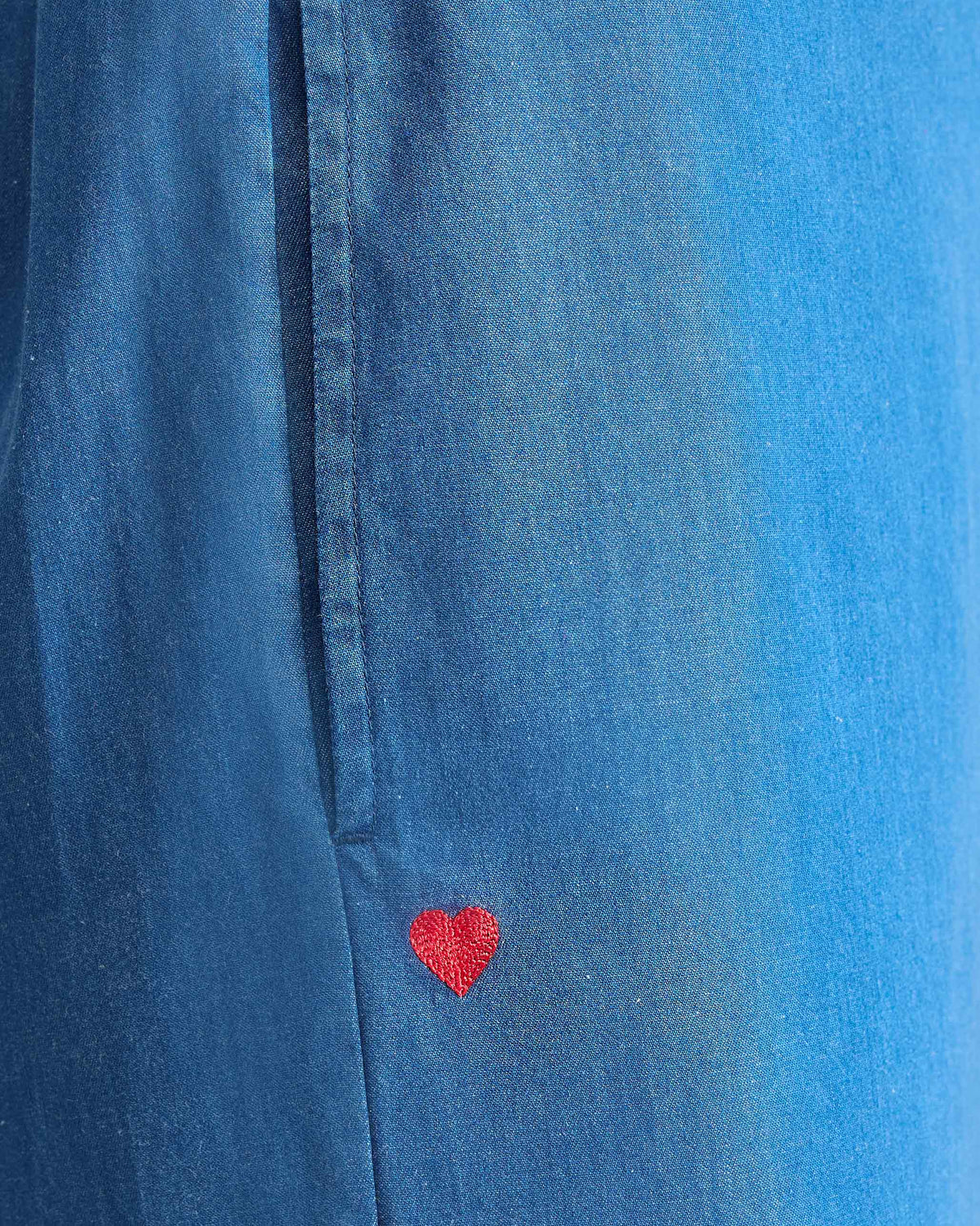 Close-up of denim blue Basic pyjamas showing a red embroidered heart.