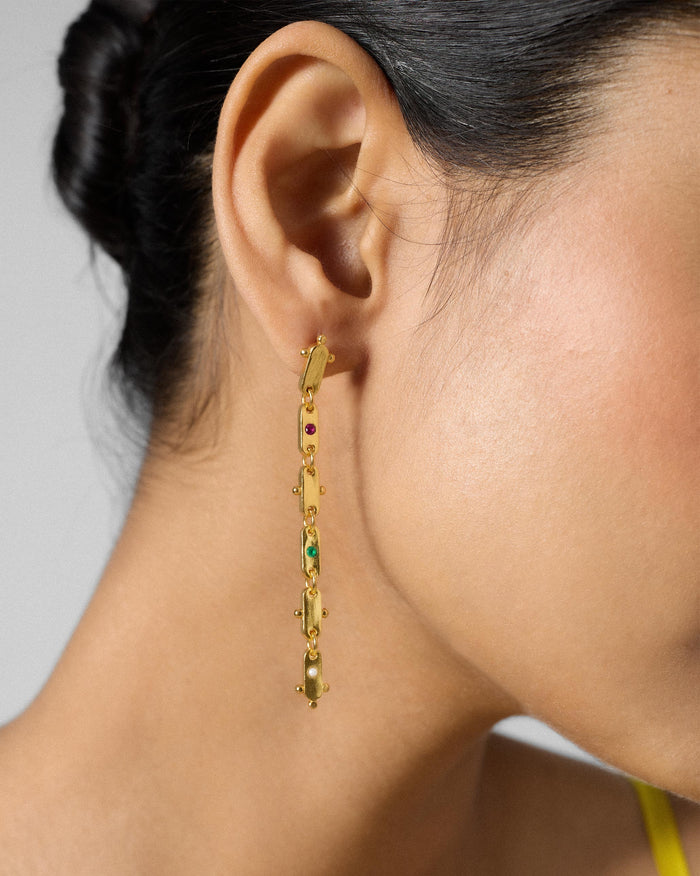 Side profile of long gold Ladder earrings with coloured glass.