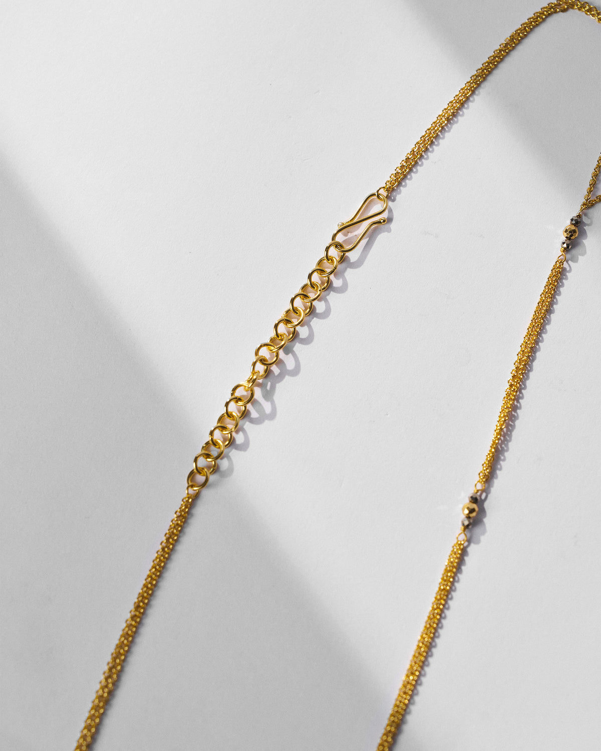 Gold Sama necklace clasp and extender chain with dark beads.