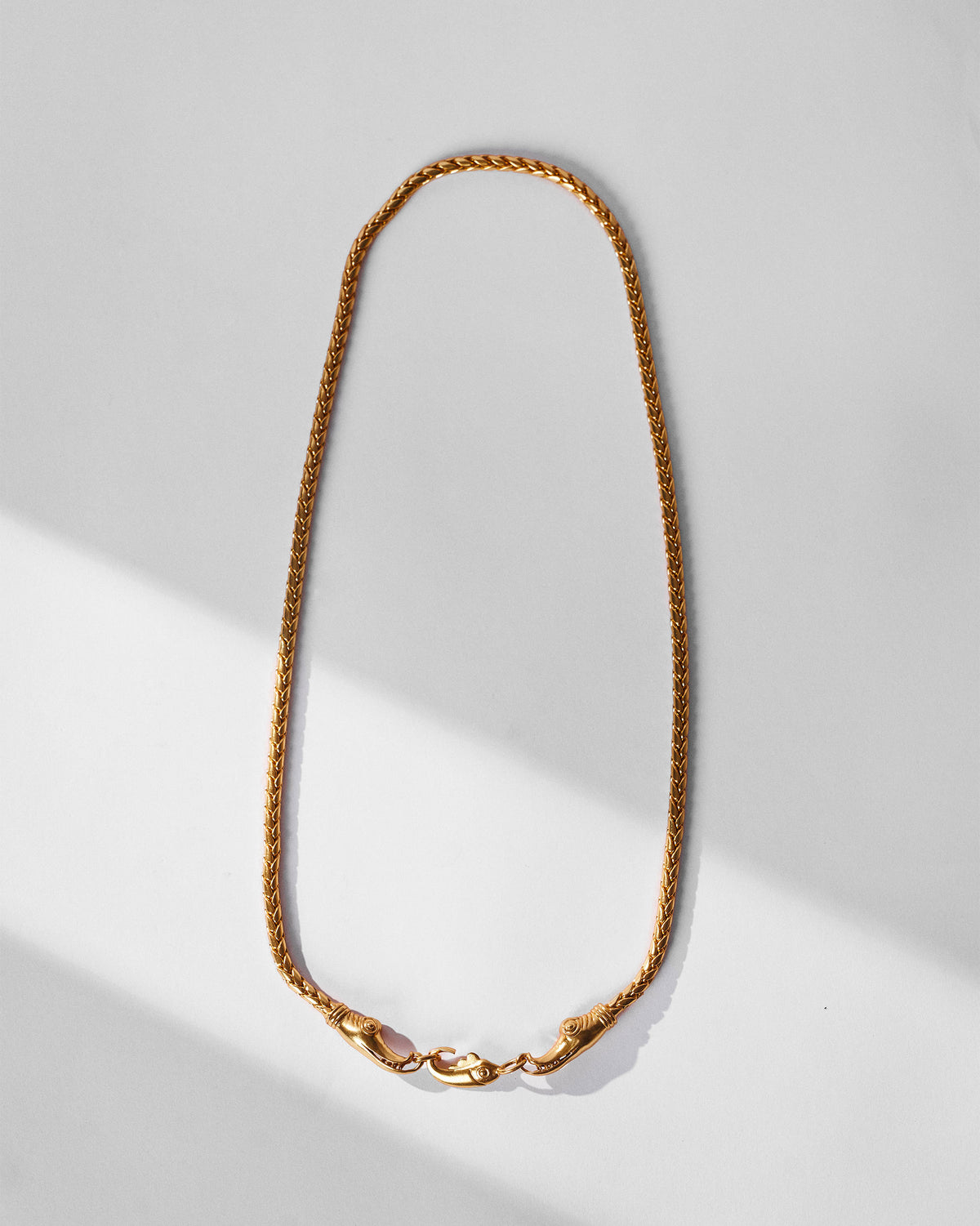 Gold Makkar wheat chain with facing makara heads and a fish-shaped clasp.