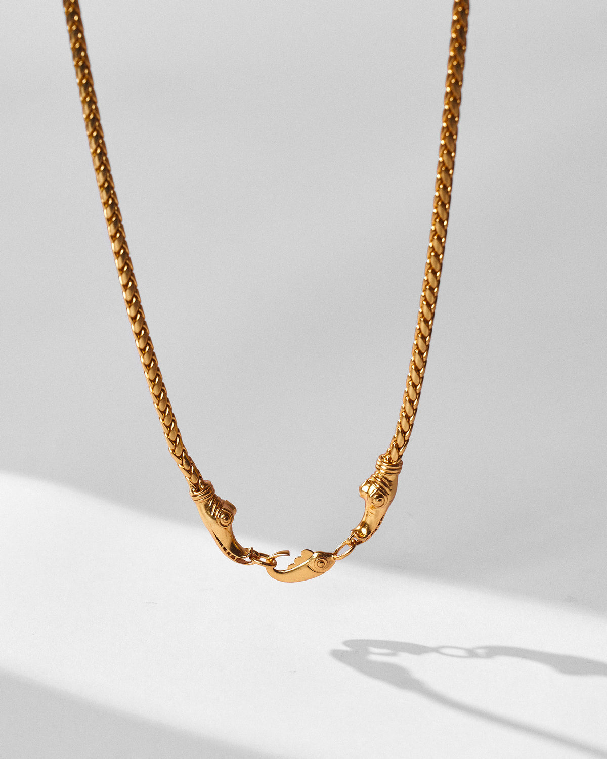 Gold Makkar chain hanging to show the braided links and front clasp.