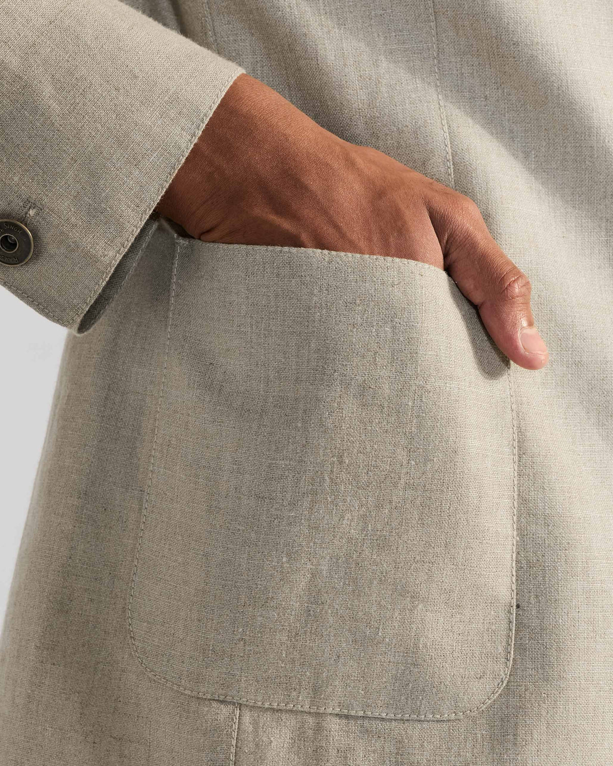 Close-up of a rounded patch pocket on a beige Tahr bandhgala.