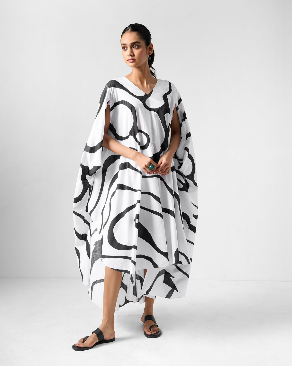 Person wearing a black and white Effy Kaftan with a river flow print.