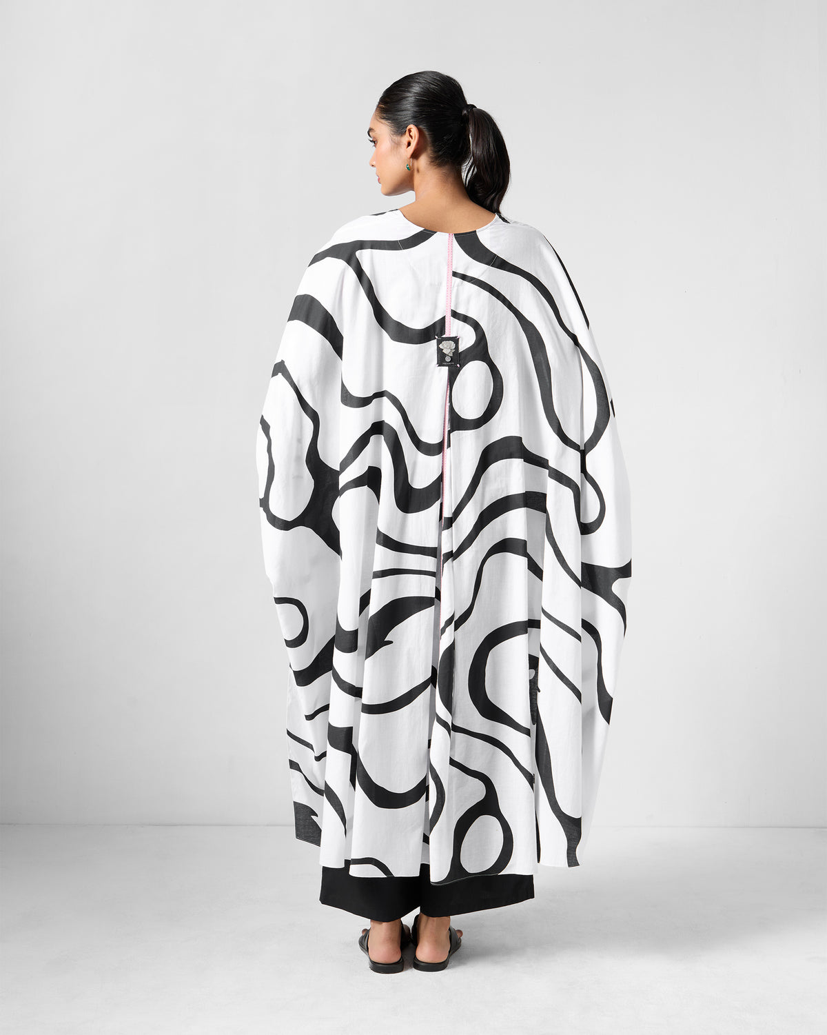 Back of a black and white Effy Kaftan with pink center-back tape.