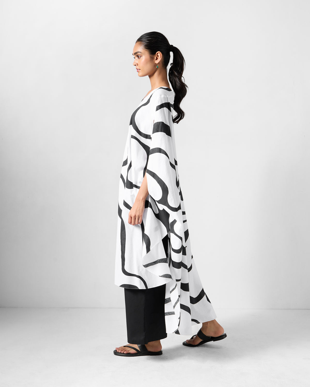 Side view of a black and white Effy Kaftan with a high-low hem.