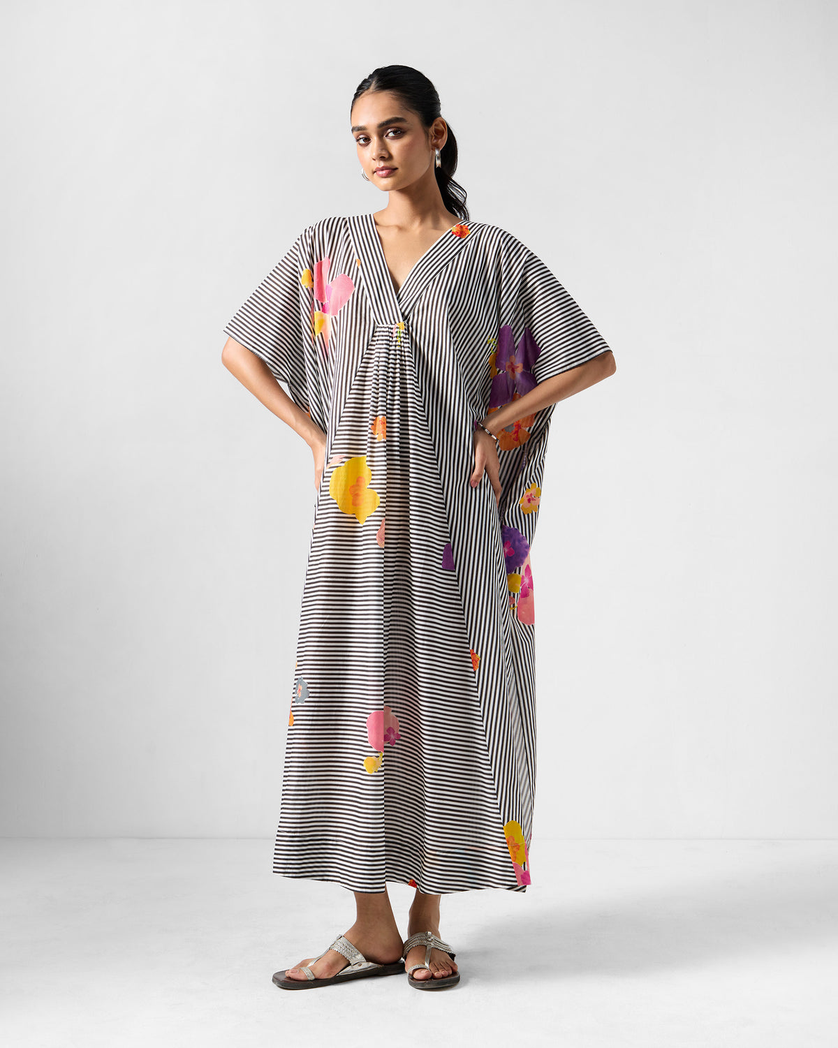 Person wearing a Noa kaftan with stripes and colourful florals.