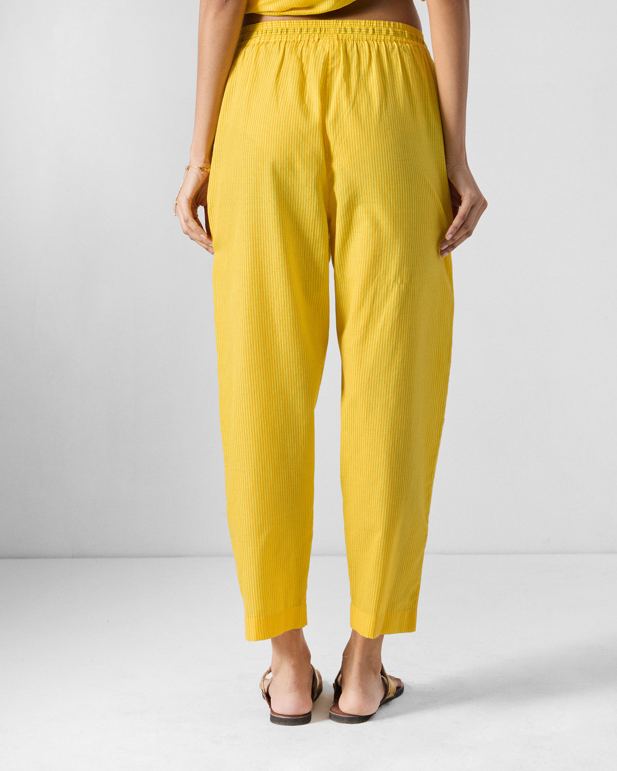 Back of yellow striped Arzoie pants with a tapered cropped fit.