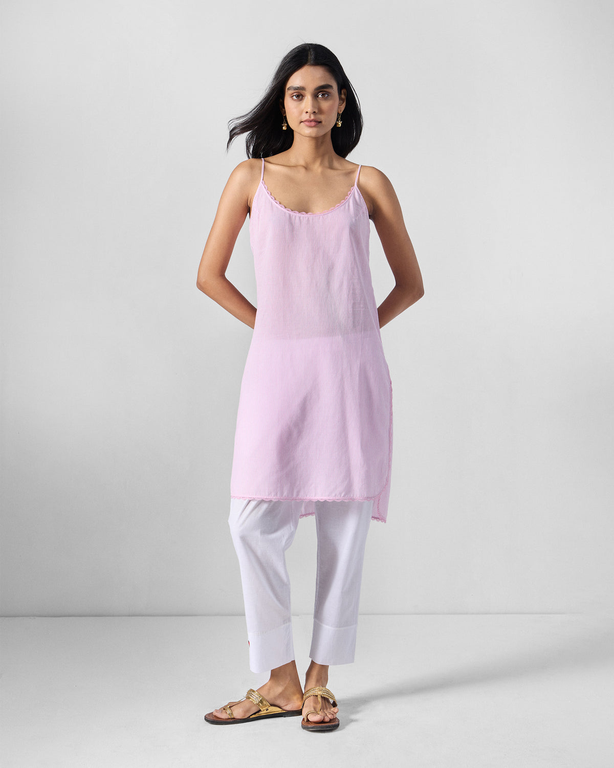 Person wearing a pink Sinatra slip with thin straps.