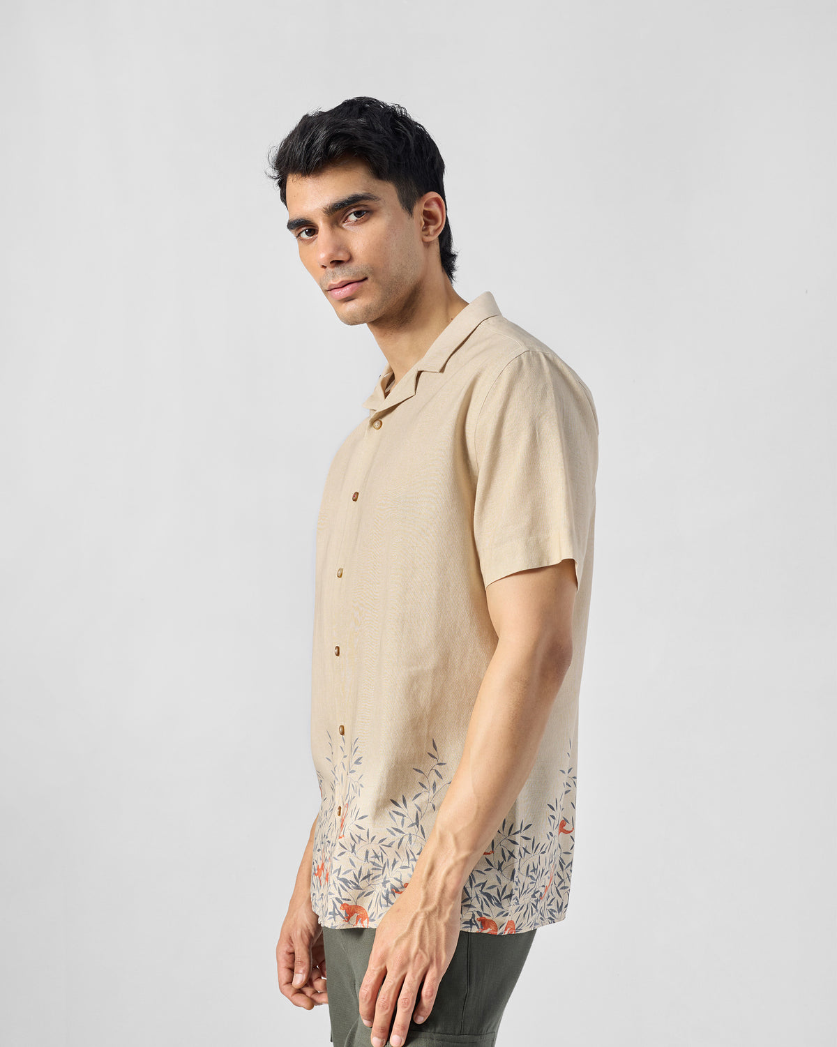 Person wearing a beige Delta shirt with a foliage hem print.