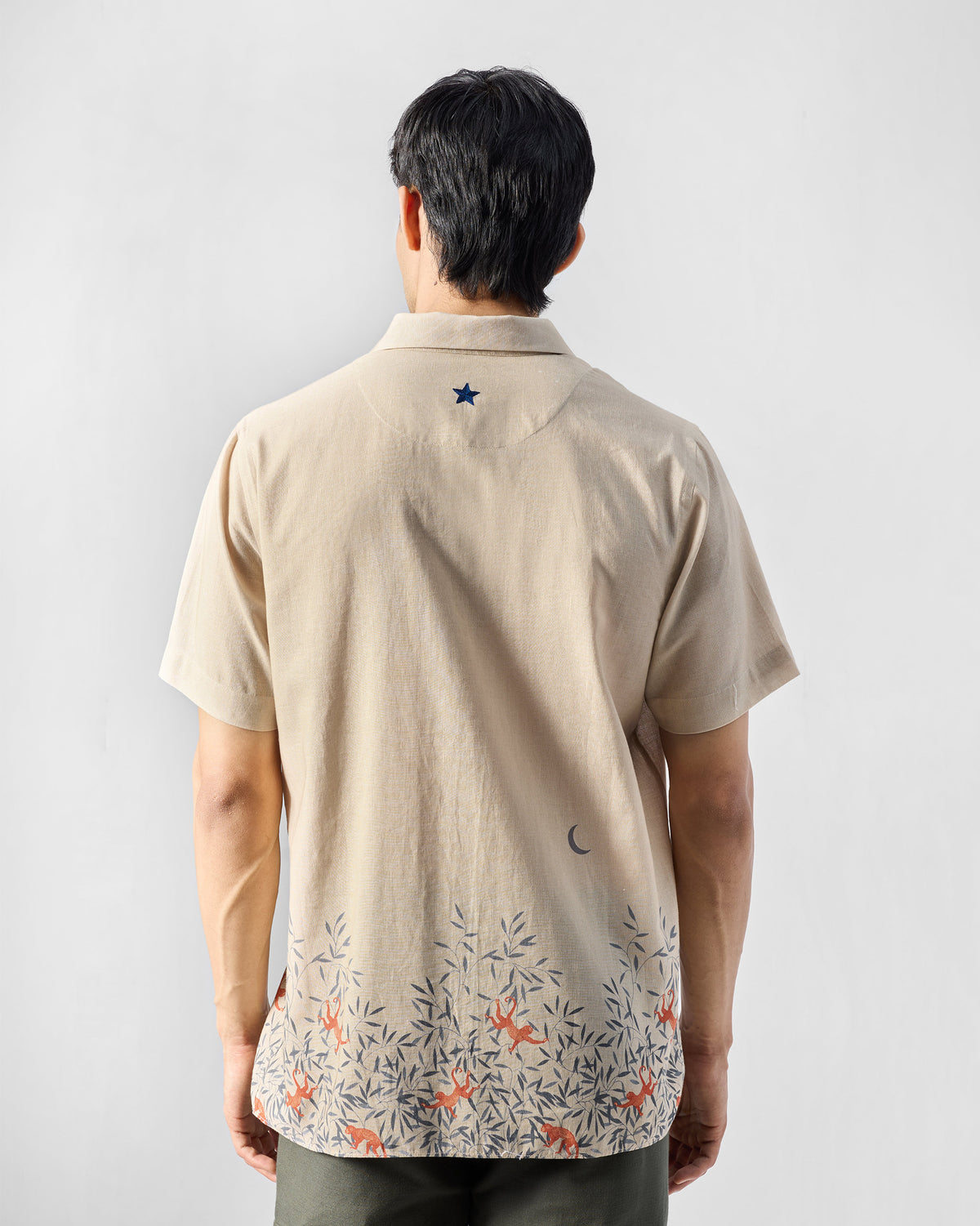 Back of a beige Delta shirt with a navy star and monkey print.