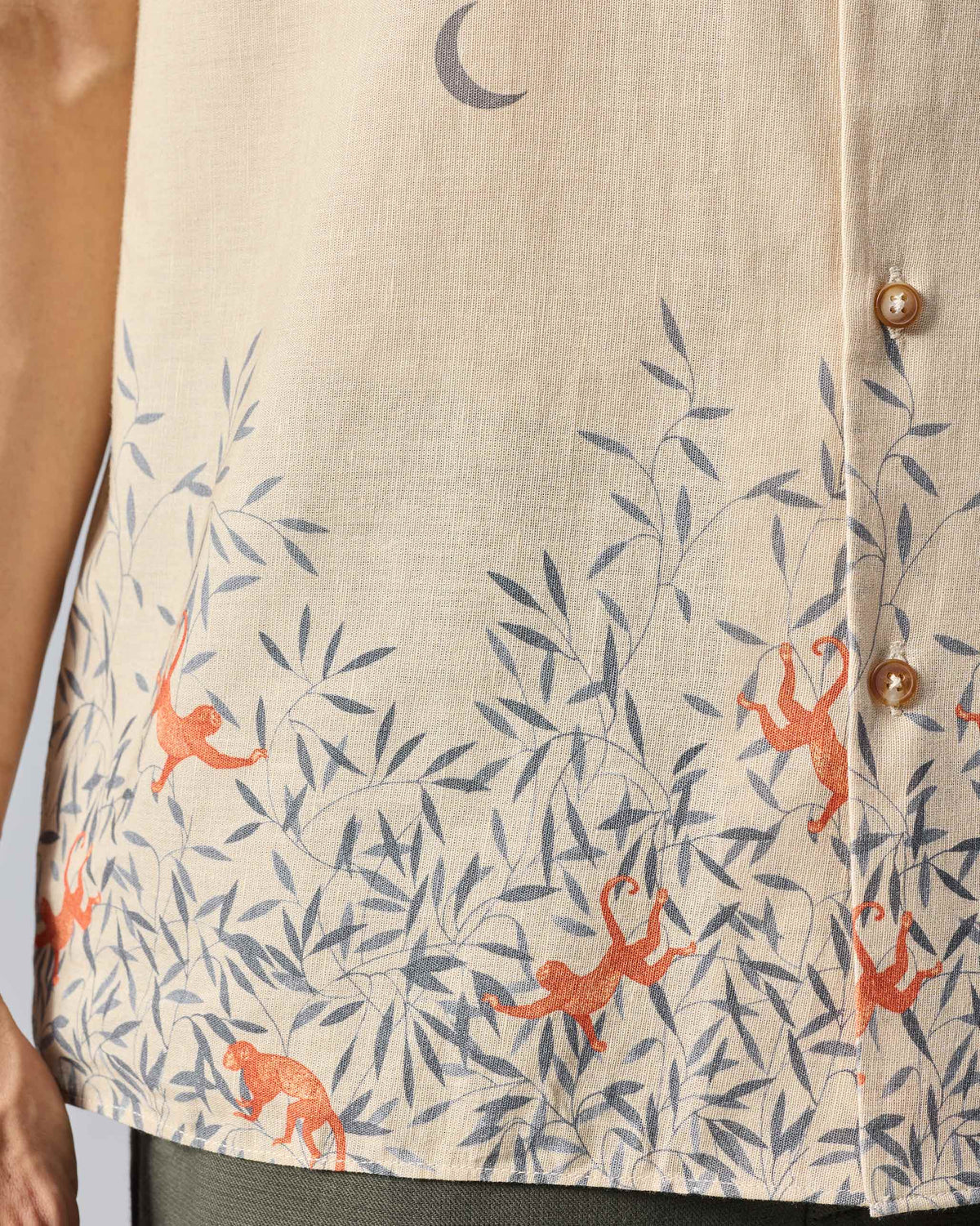 Close-up of a beige Delta shirt showing monkeys in the hem print.