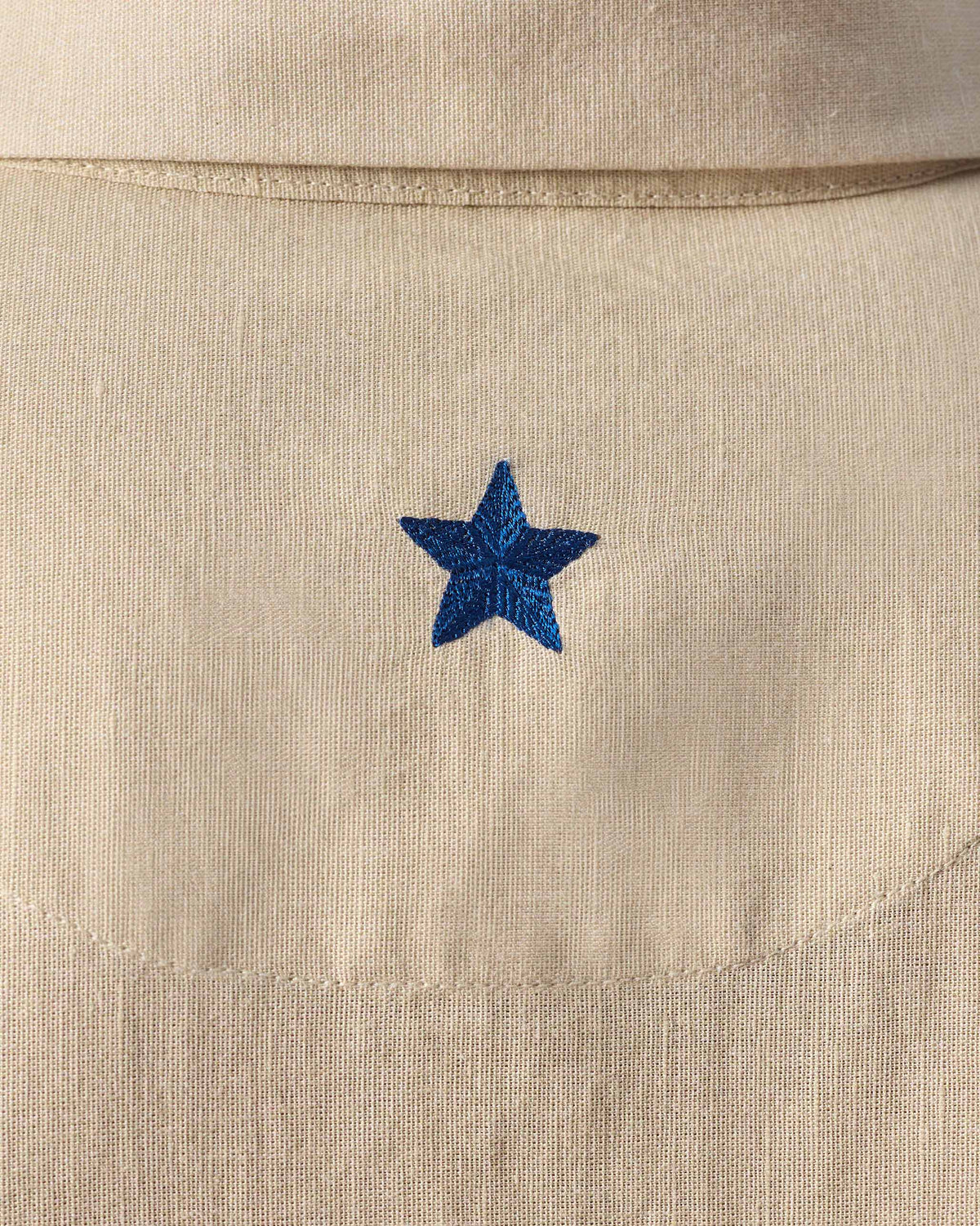 Close-up of a navy star on the back of a beige Delta shirt.