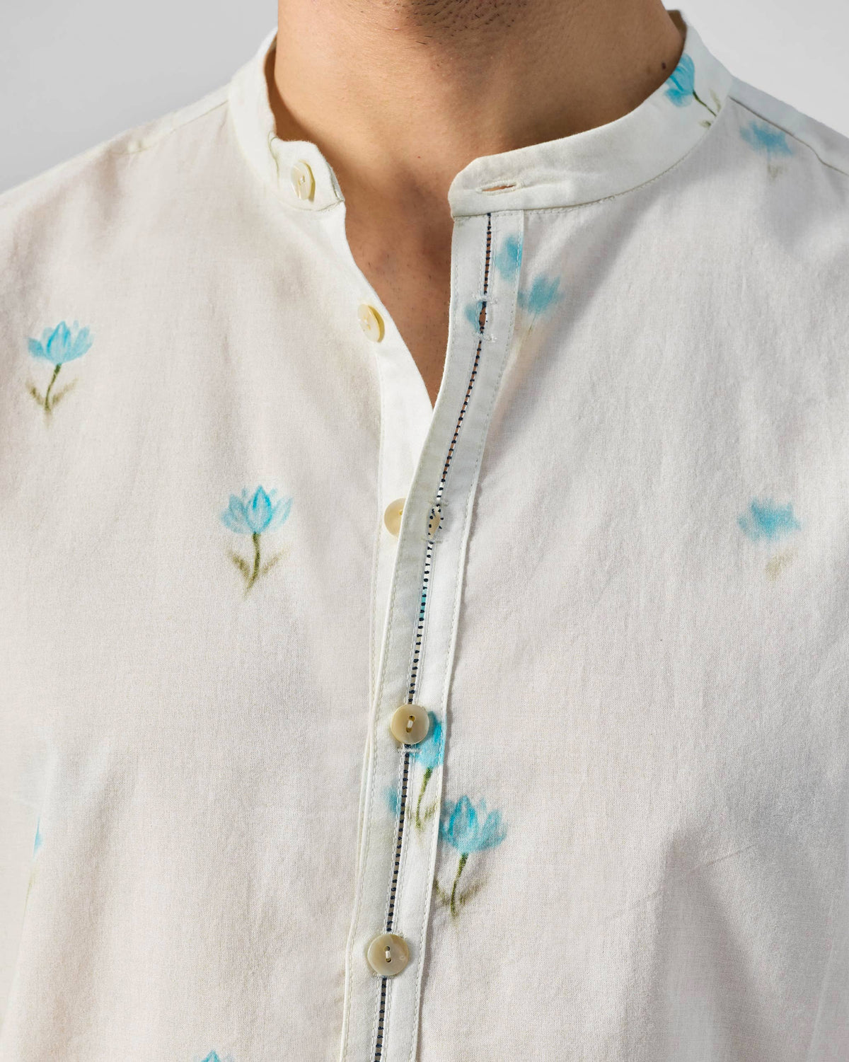 Close-up of an ivory Astral kurta collar with light blue lotus print.
