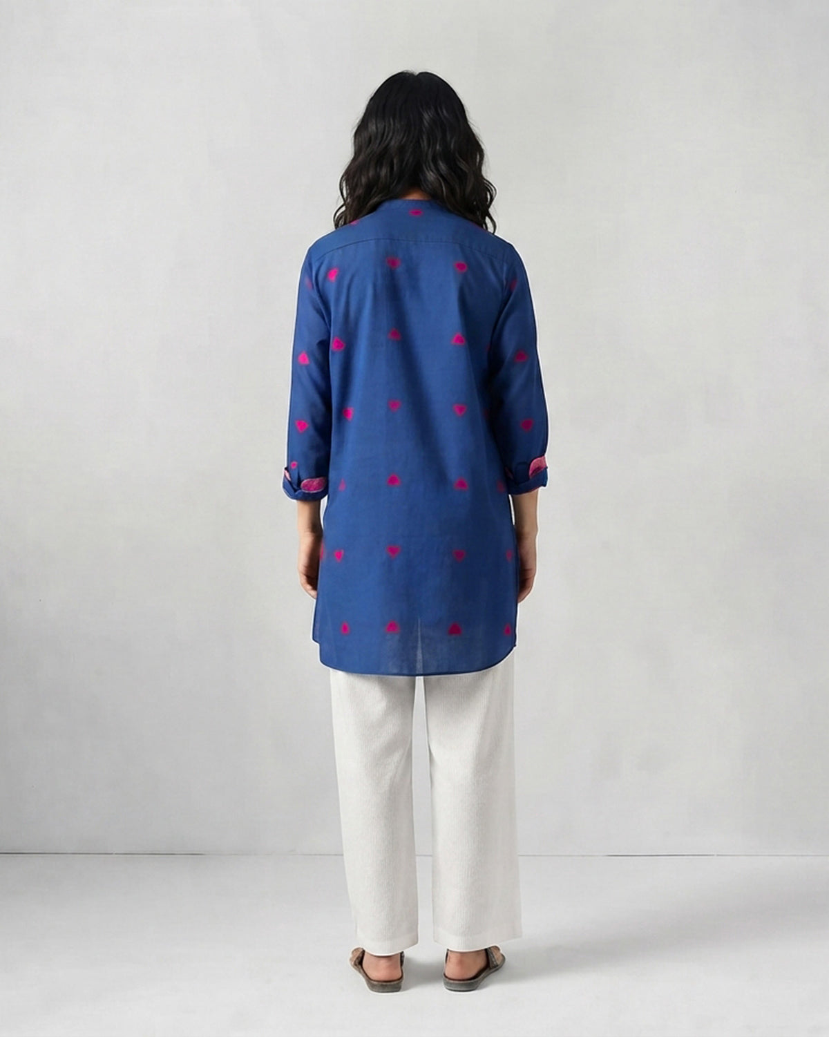 Back of a navy Fort kurta with small red motifs worn by a person.