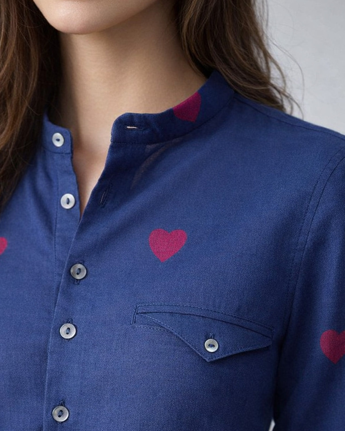 Close-up of a navy Fort kurta with red heart motifs and a flap pocket.