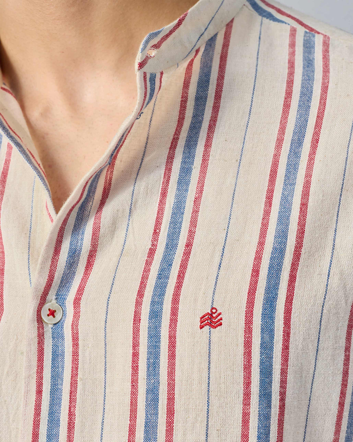 Close-up of Nawab Shirt band collar, stripes, and red chest embroidery.
