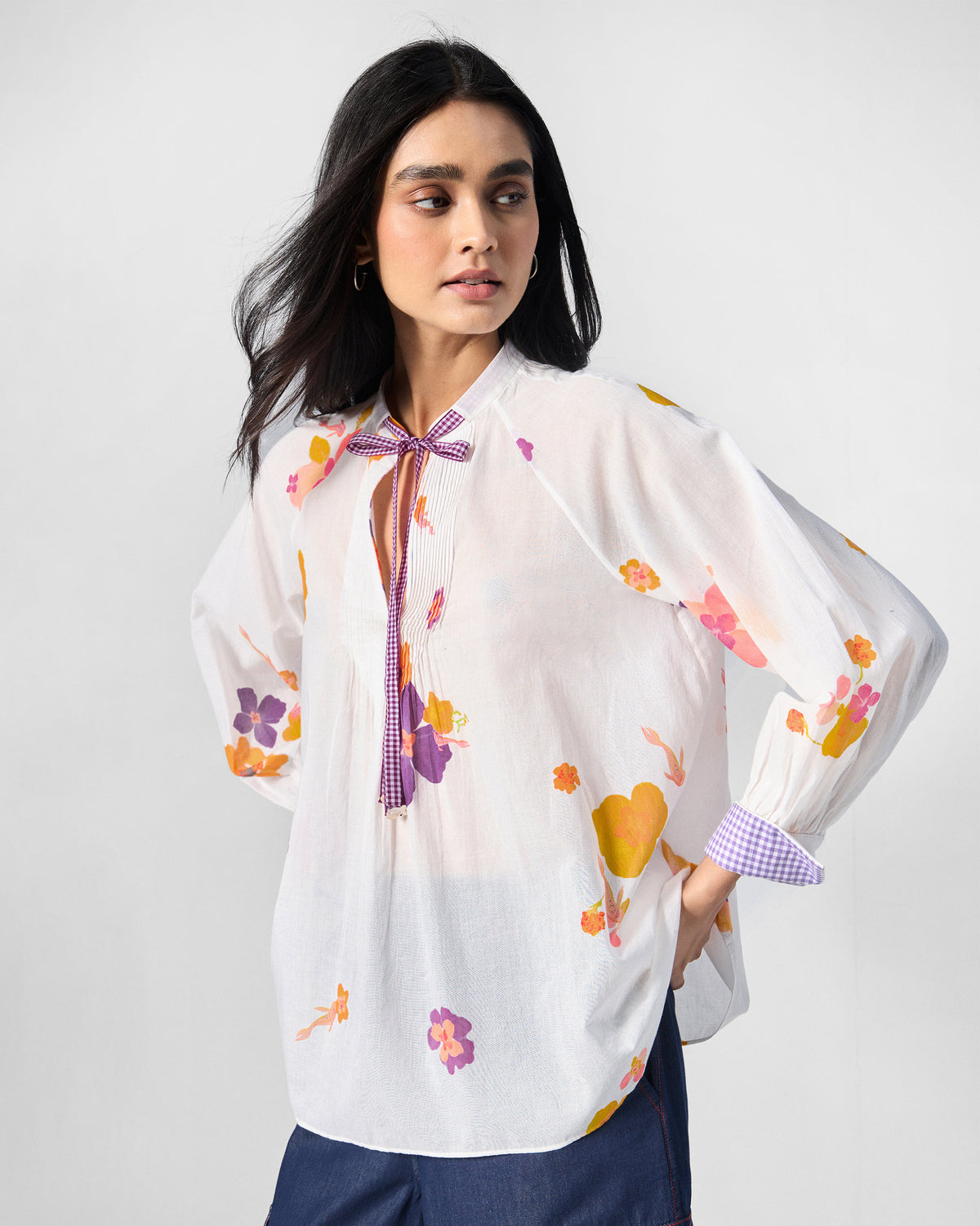 Flutter Blouse in ivory floral print with purple check bow and cuffs.