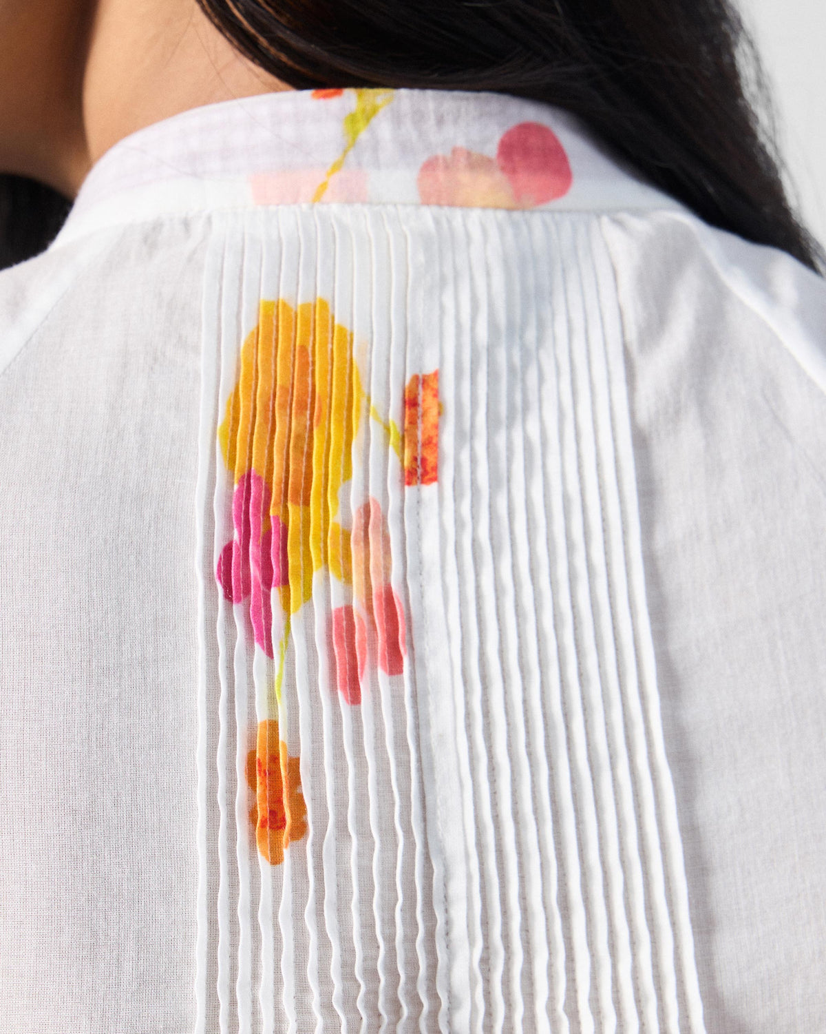 Close-up of Flutter Blouse back pintucks with yellow and pink florals.