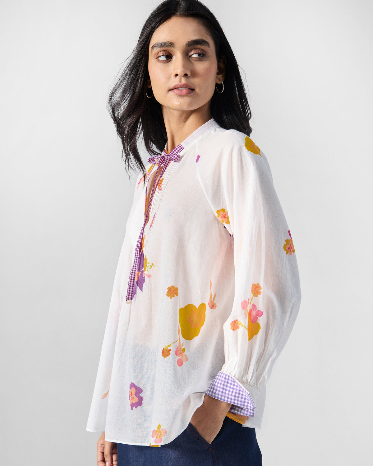 Flutter Blouse side view in ivory floral print with purple check cuffs.