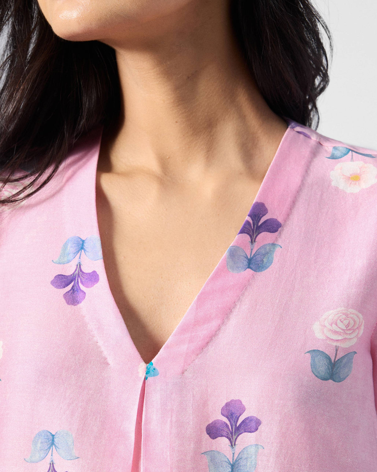 Close-up of a soft pink Hera Kurta V-neck with purple floral print.