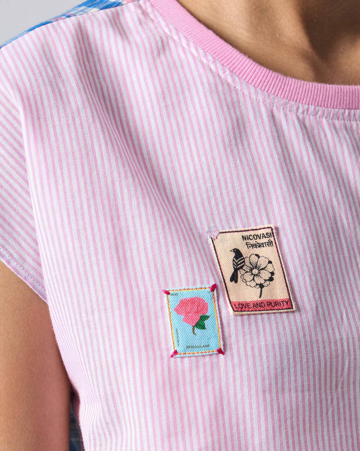 Close-up of stamp patches on the pink striped Faye top.