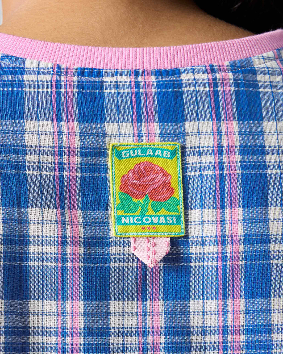 Close-up of the rose label on the check back of a Faye top.